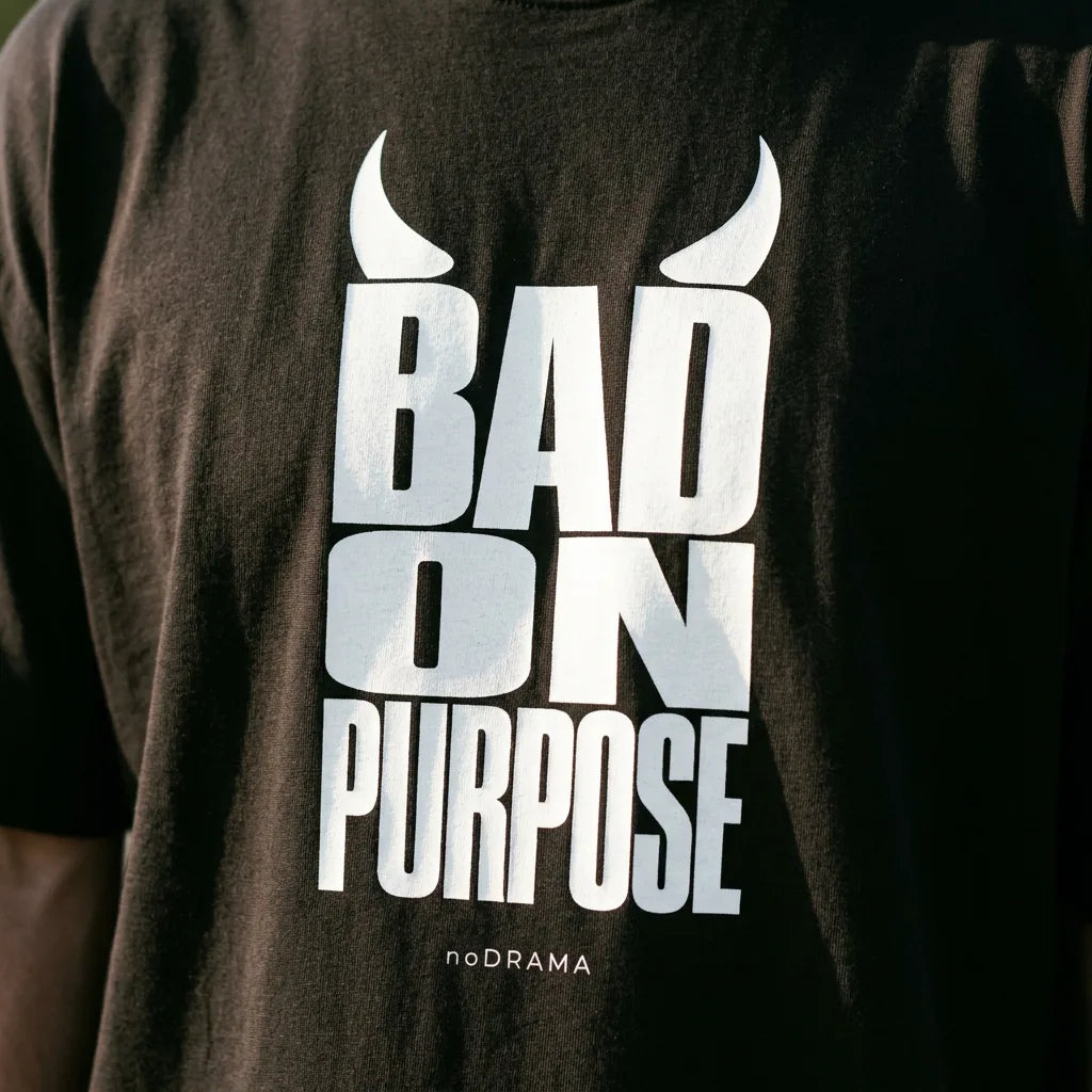 Близък план на принта Bad on Purpose с рогца върху черна тениска noDRAMA