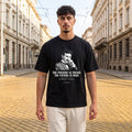 Мъж с черна oversized тениска Тесла по жълтите павета в София noDRAMA