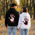 Двойка в черен и бял oversized суитшърт с длан и „любов“ на гърба, есенен парк